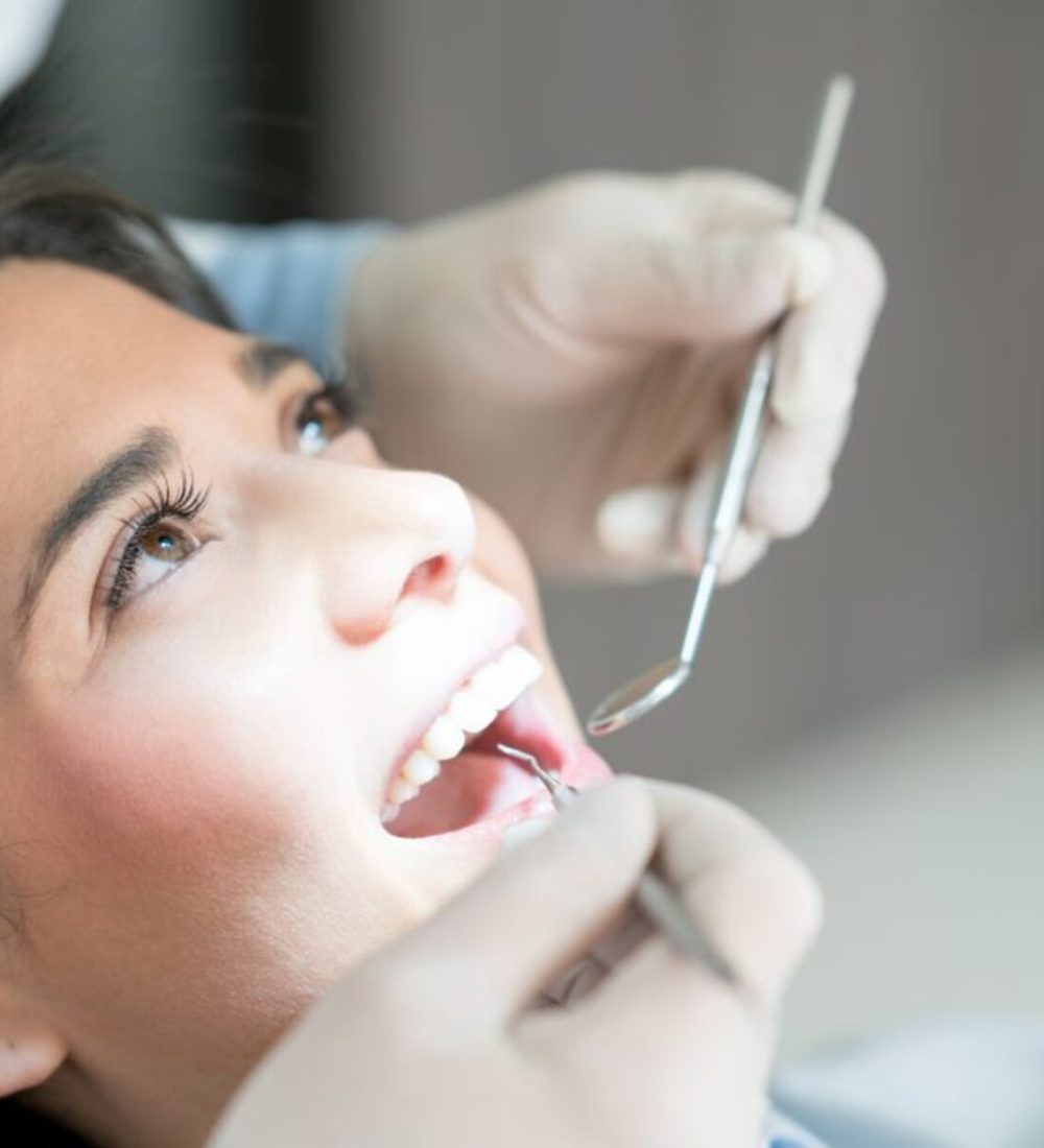 Dentist gently cleaning a patient's teeth during a scaling and polishing appointment