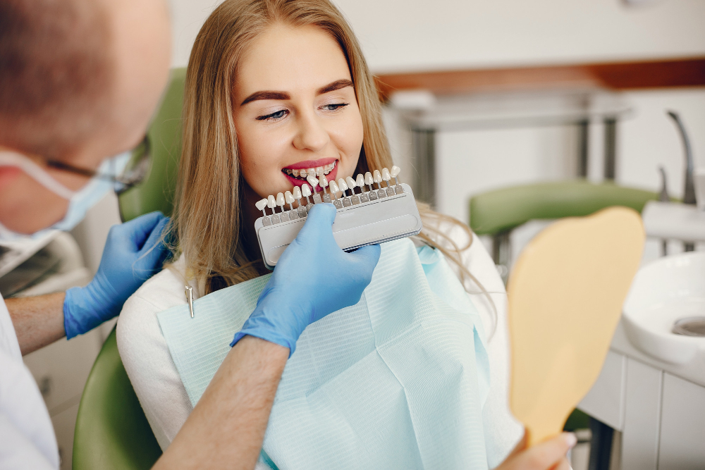 Smiling patient matching an E Max veneer shade to her teeth
